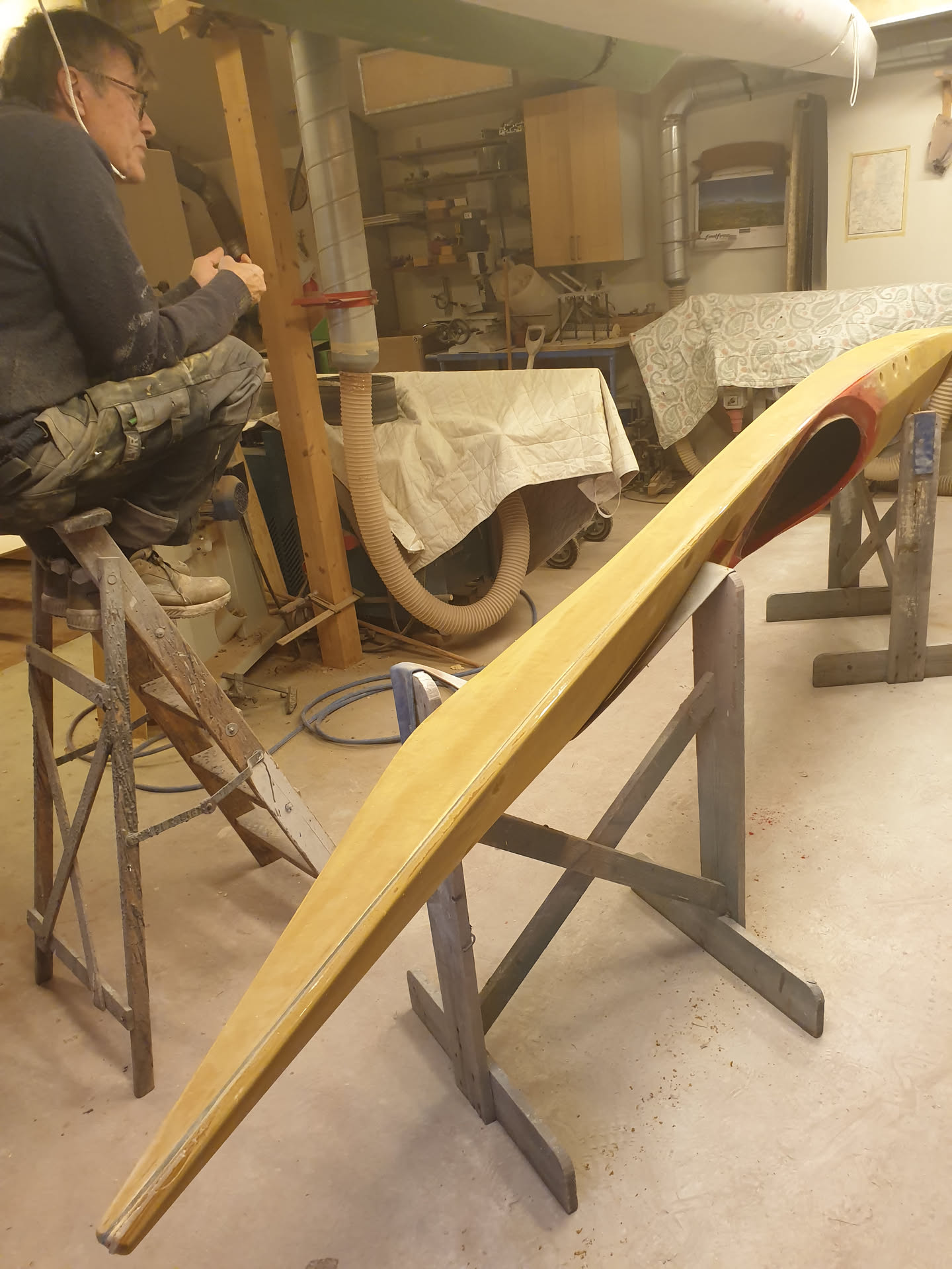Johan Wirsén on a ladder looking at the Naja kayak prototype